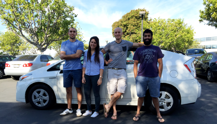 four people leaning on a car