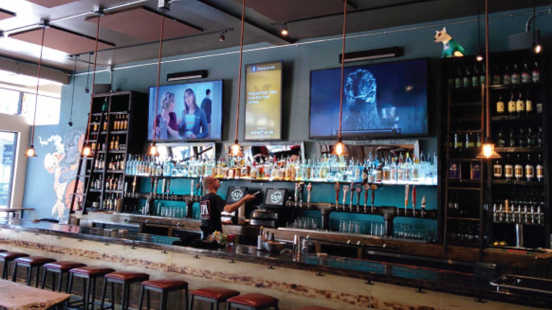 man behind a bar adjusting displays