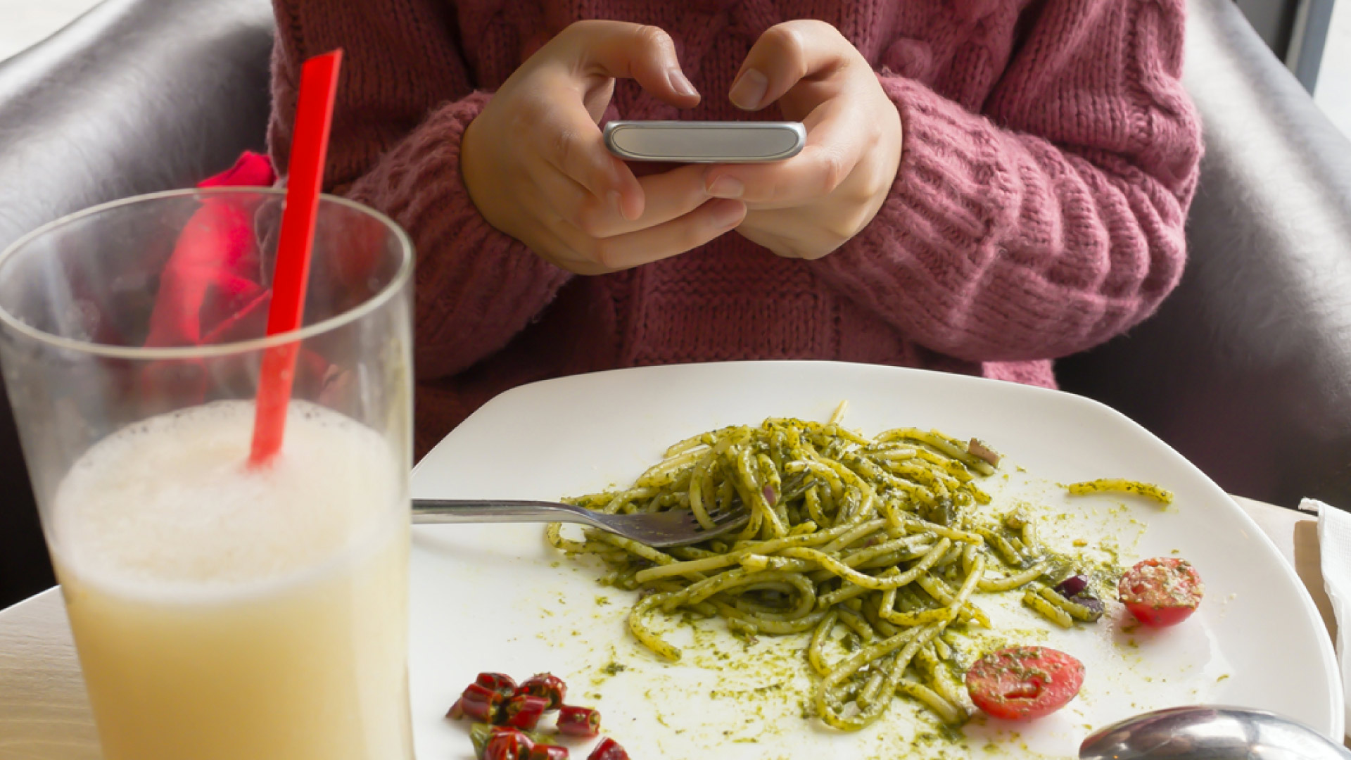 person on phone at restaurant table