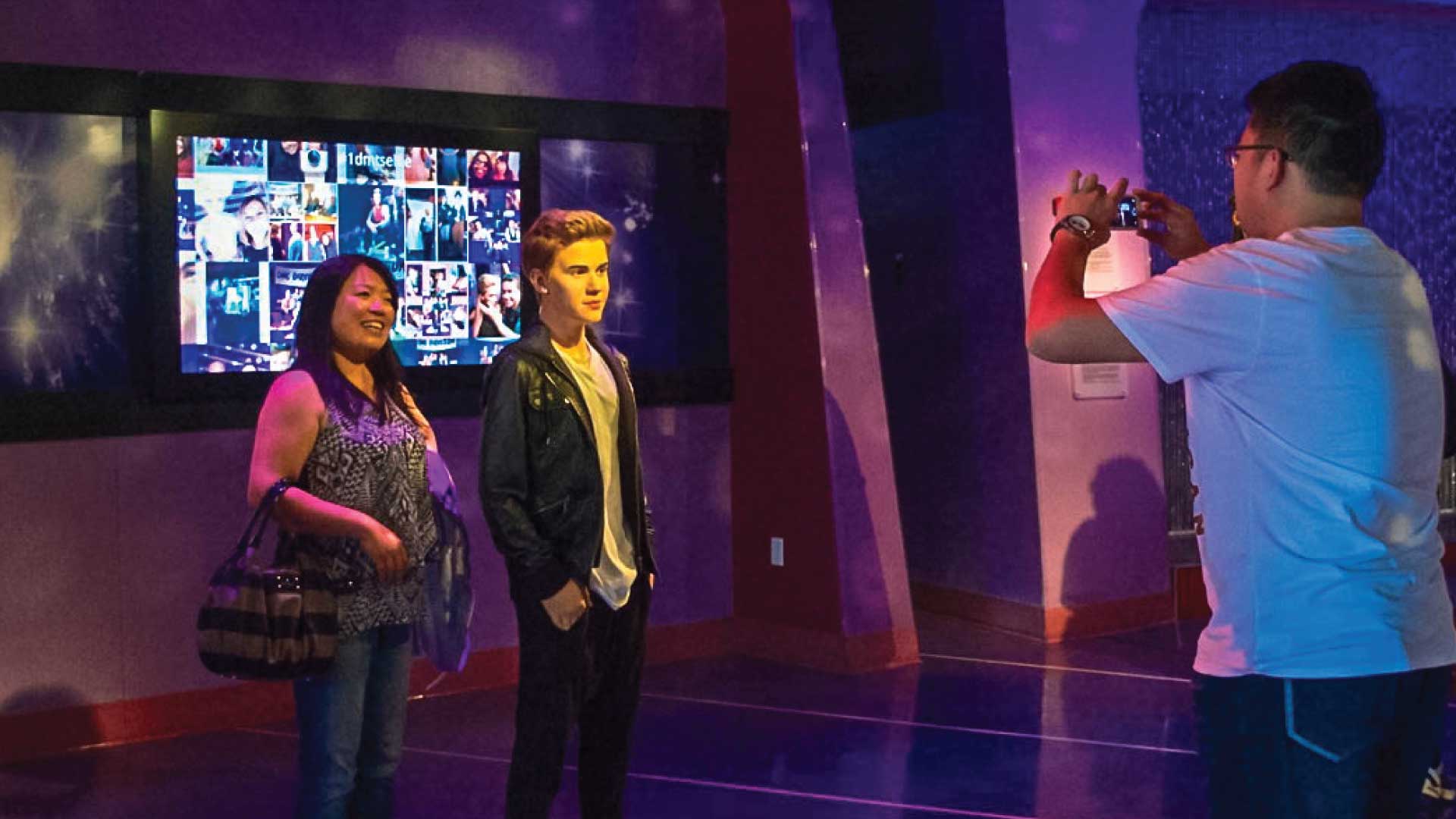 lady takes photo with a wax sculpture