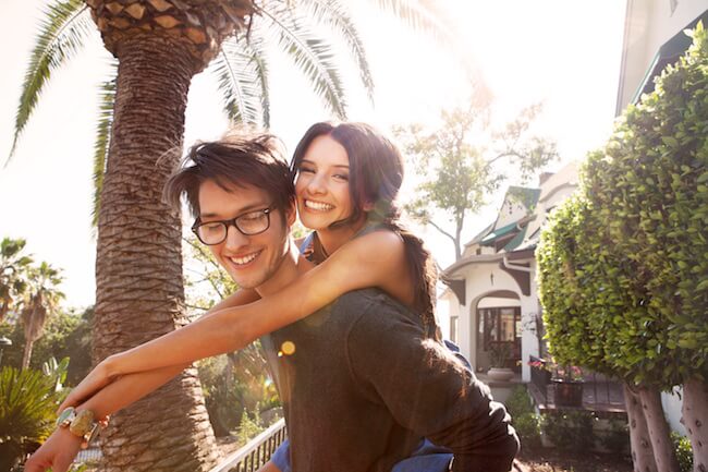 happy couple in front of a house