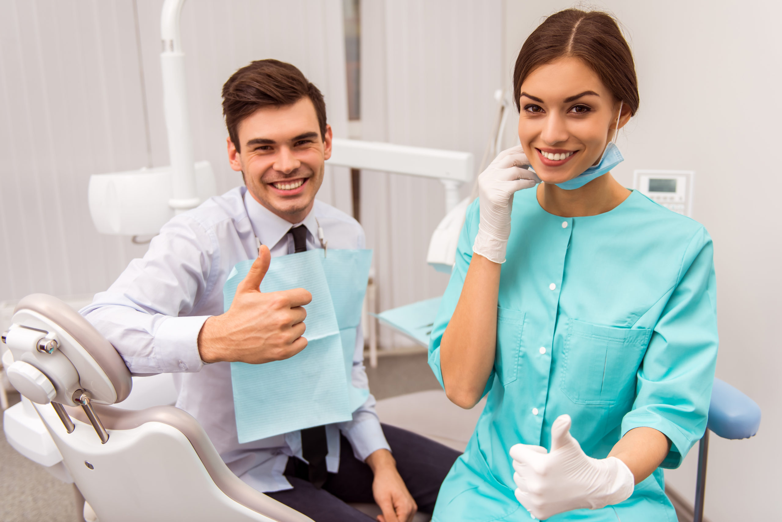 two dentists smiling with thumbs up at their chair