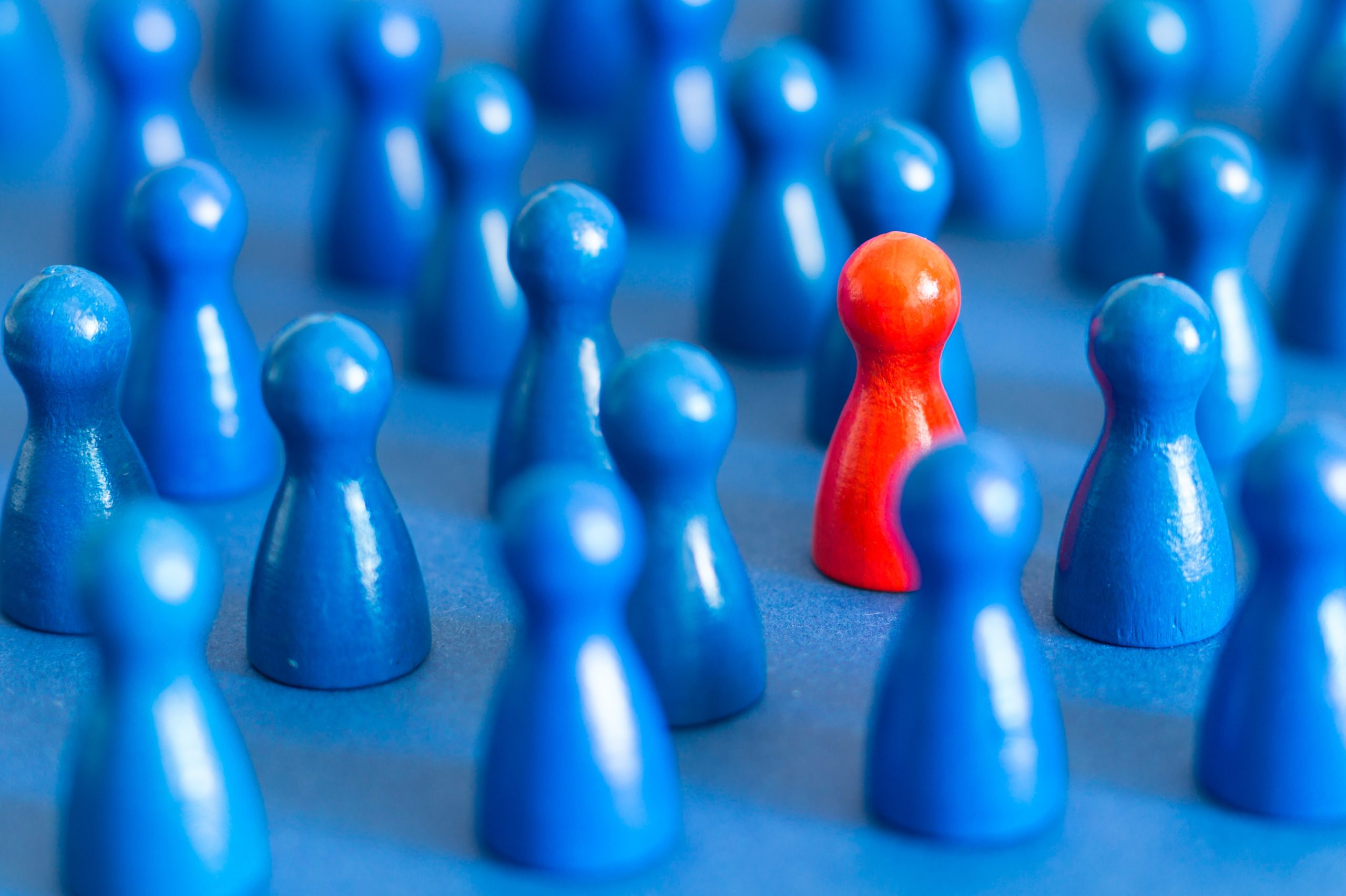 numerous blue game pieces with one red one in the middle