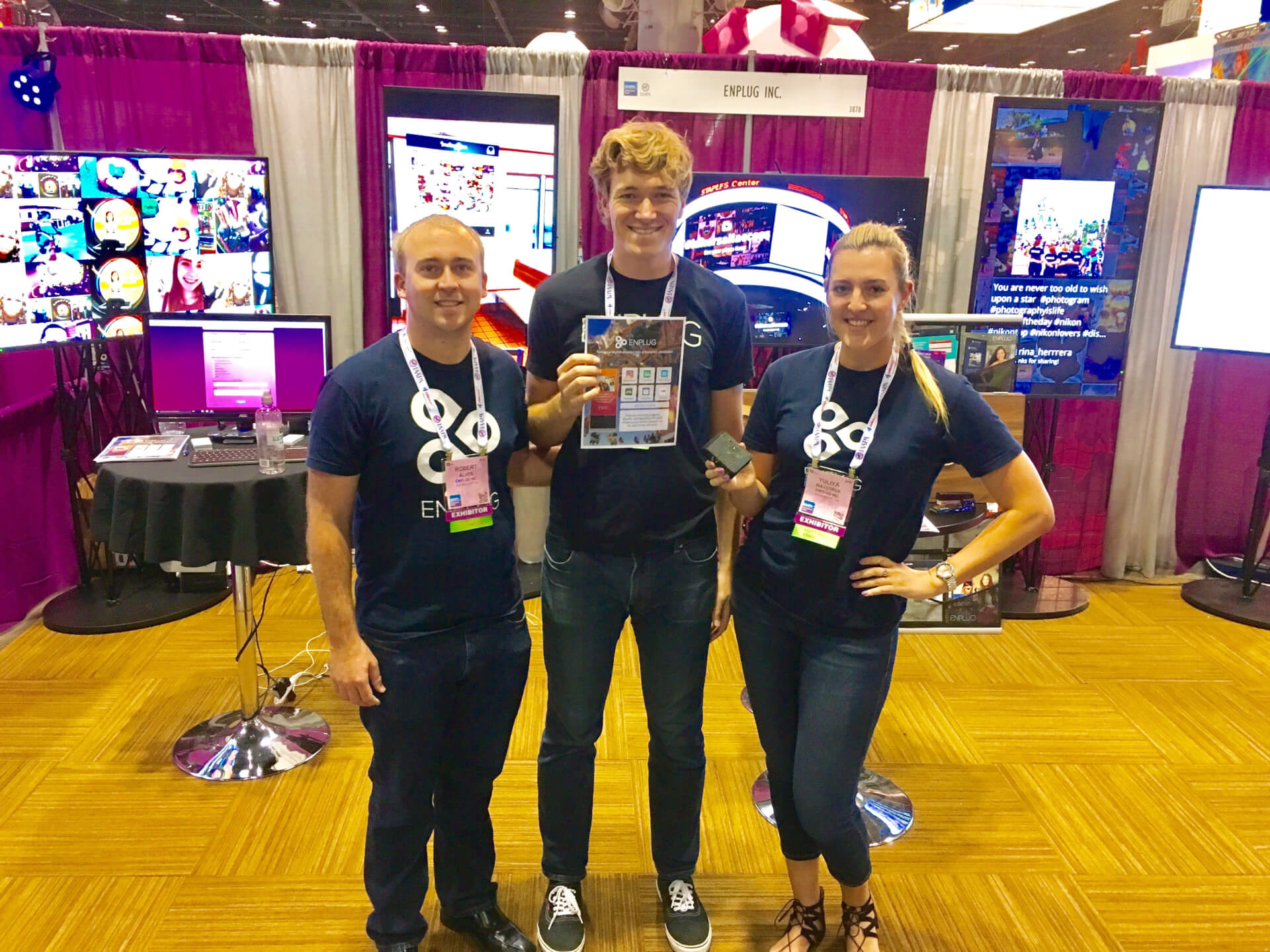 three coworkers in front of a tradeshow booth