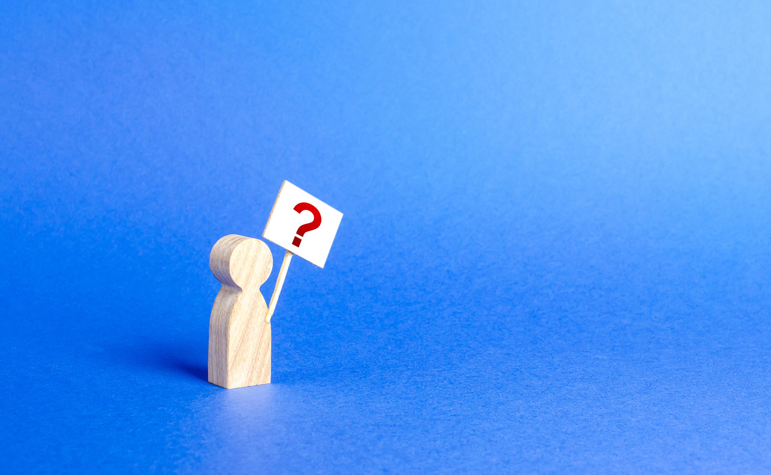 wooden figure of a person holding a question flag