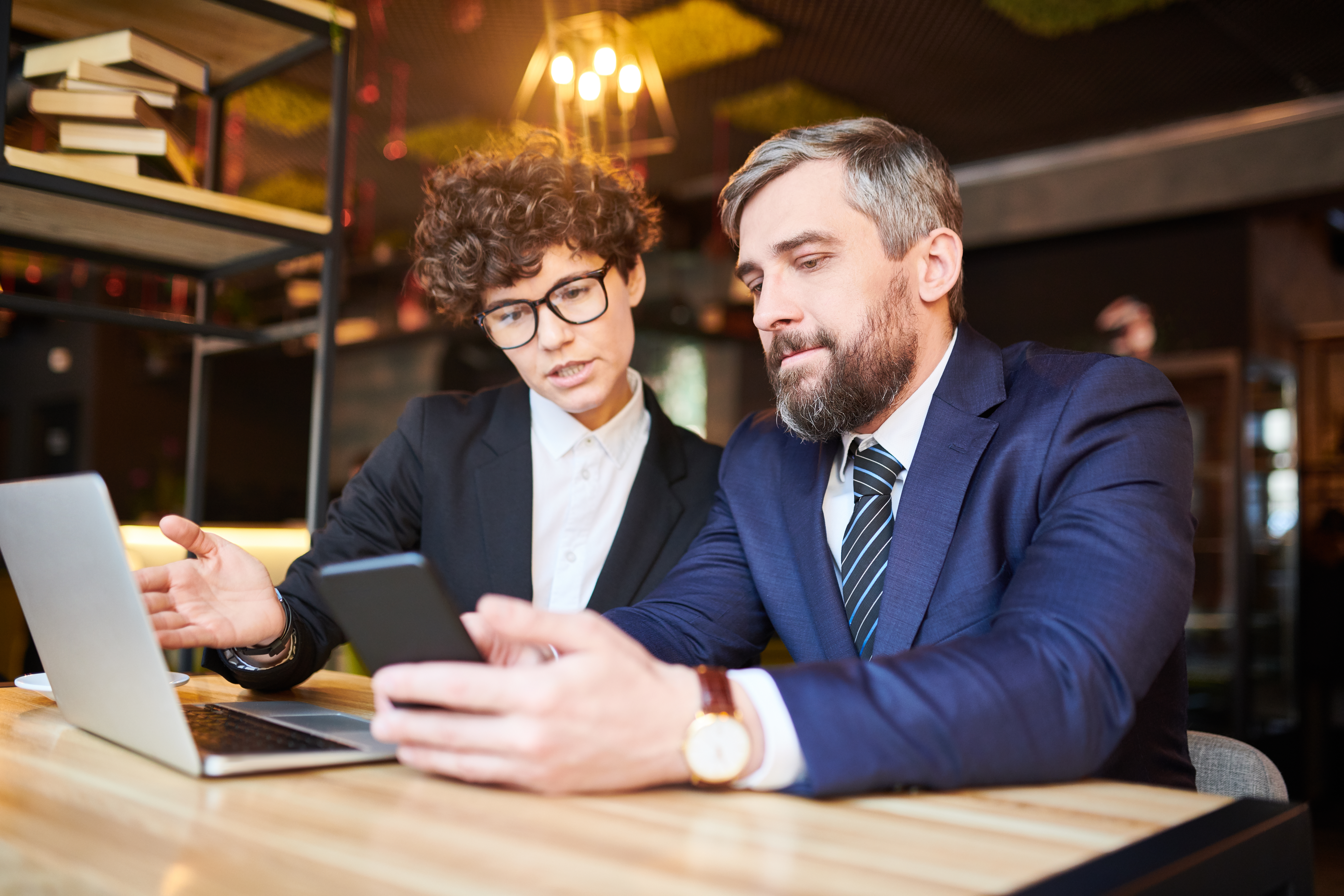 two business people comparing at a compare with their phones