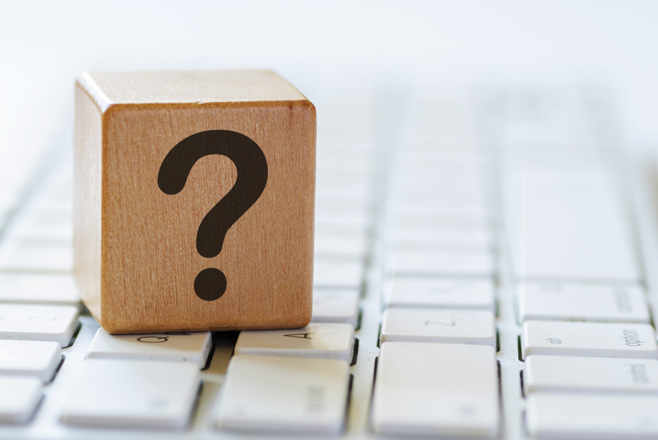 wooden block with a question mark on top of a keyboard