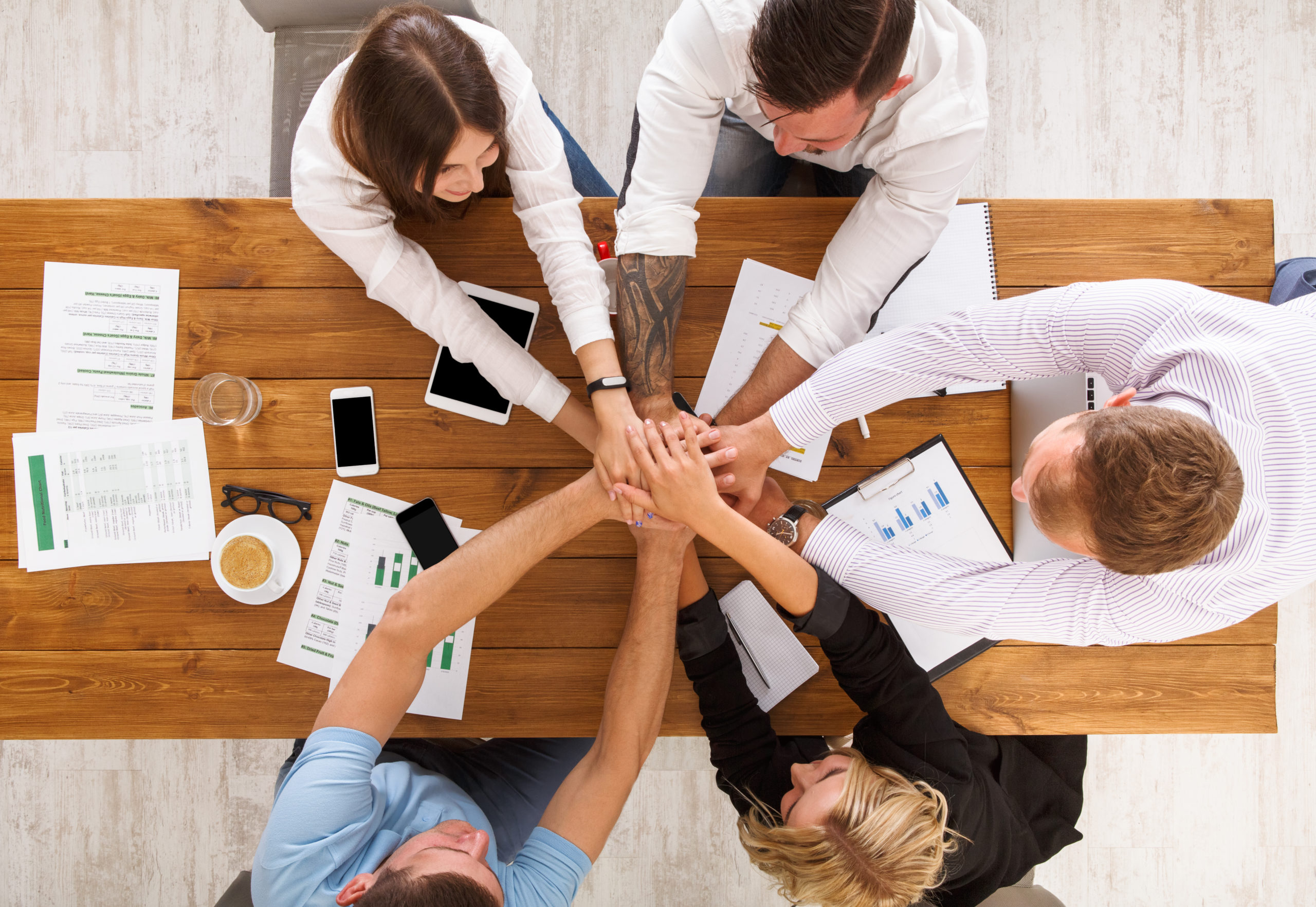 workteam meeting hands at the center of a table