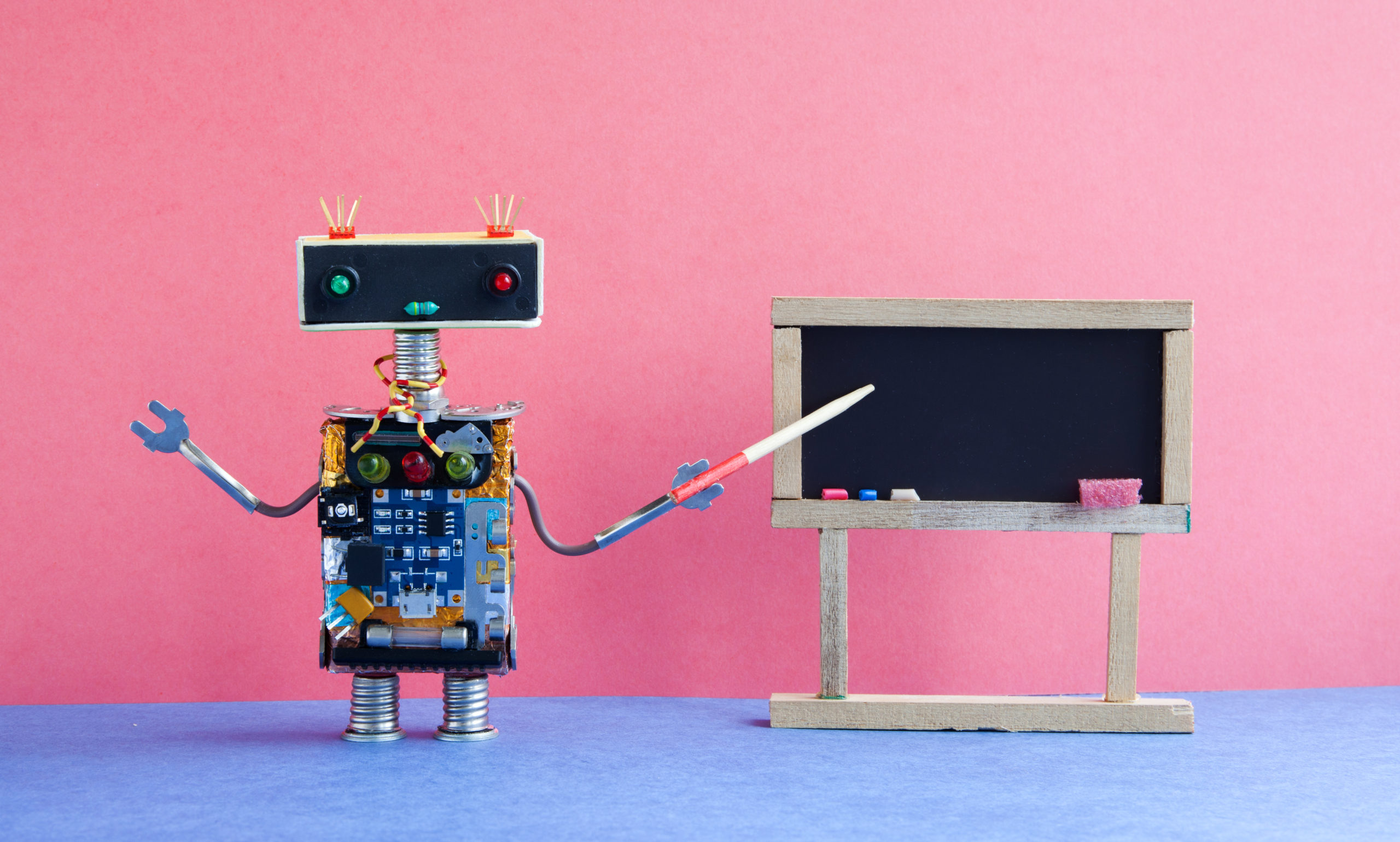 robot pointing to a chalkboard, explaining