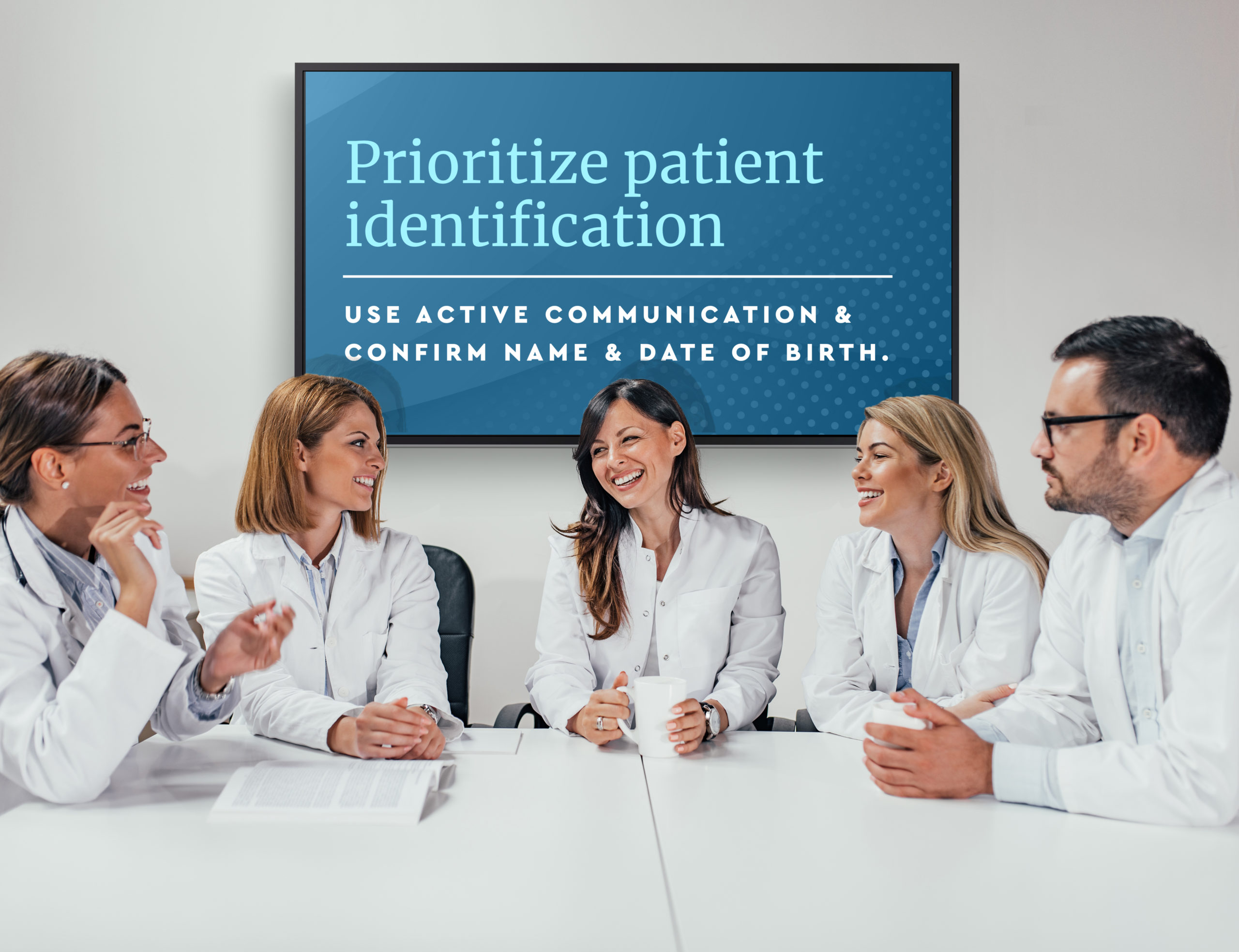 5 healthcare professionals sitting at a white table with a healthcare digital menu board behind them