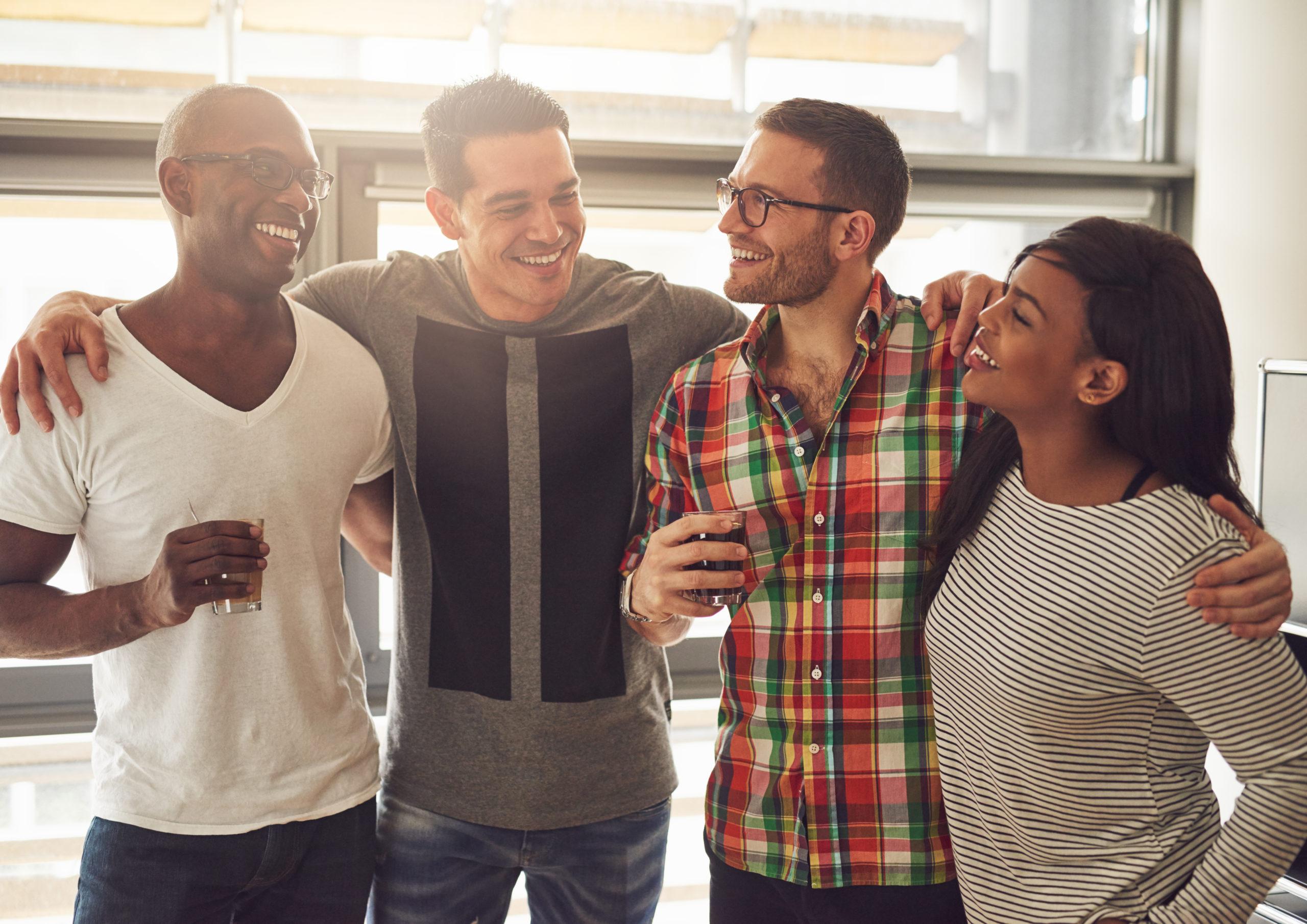 four coworkers laughing and embracing