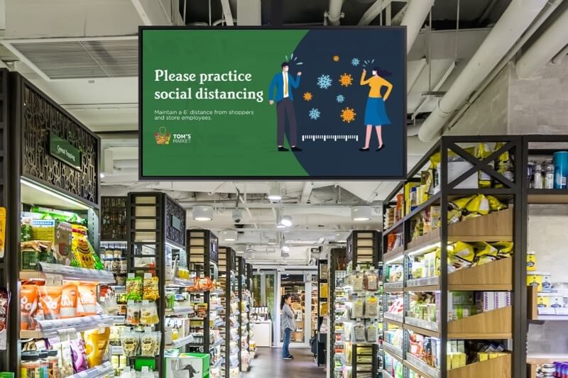 Digital signage promoting social distancing in a grocery store aisle
