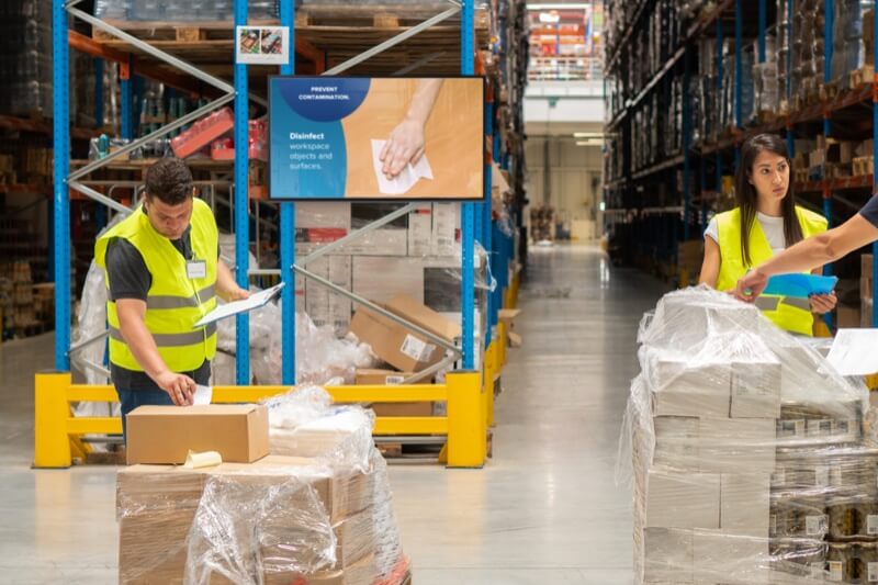 TV screen showing coronavirus communications to warehouse workers