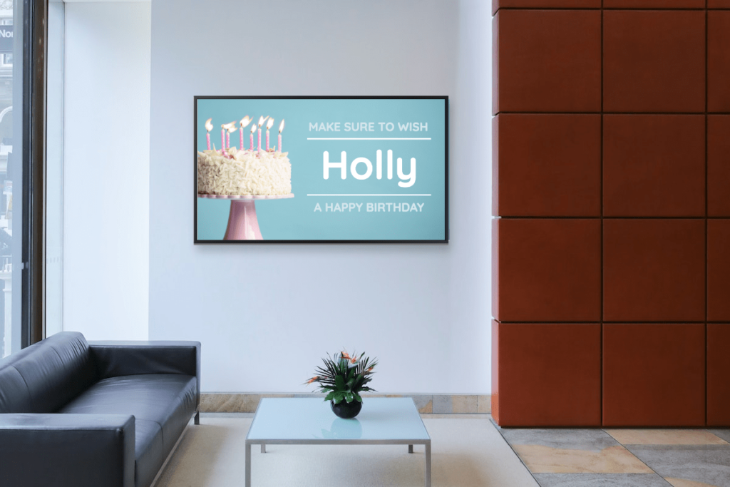 digital display reminding employees to wish a coworker happy birthday hanging in a lobby