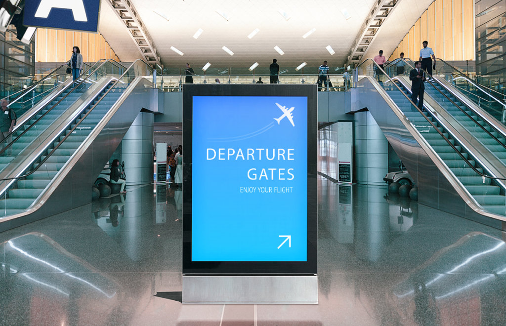 Digital wayfinding sign in airport with directions to departure gates
