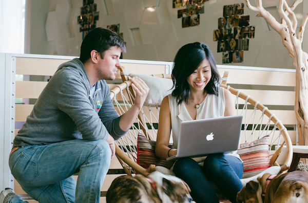 two people smiling working on a laptop