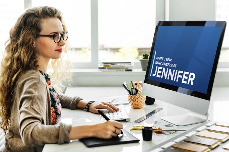 woman working at computer with custom message to her on screen