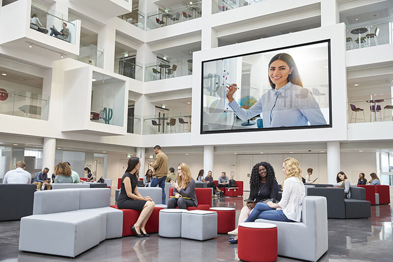 large open meeting place with a large digital display overlooking a group