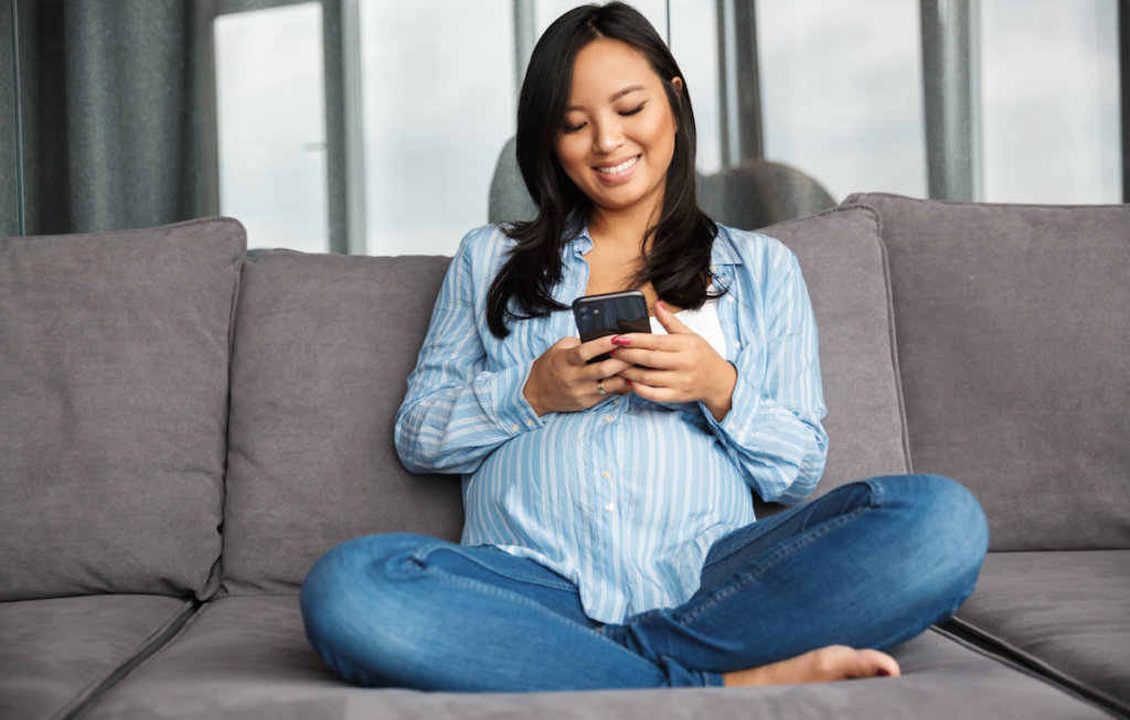 Pregnant woman uses mobile device