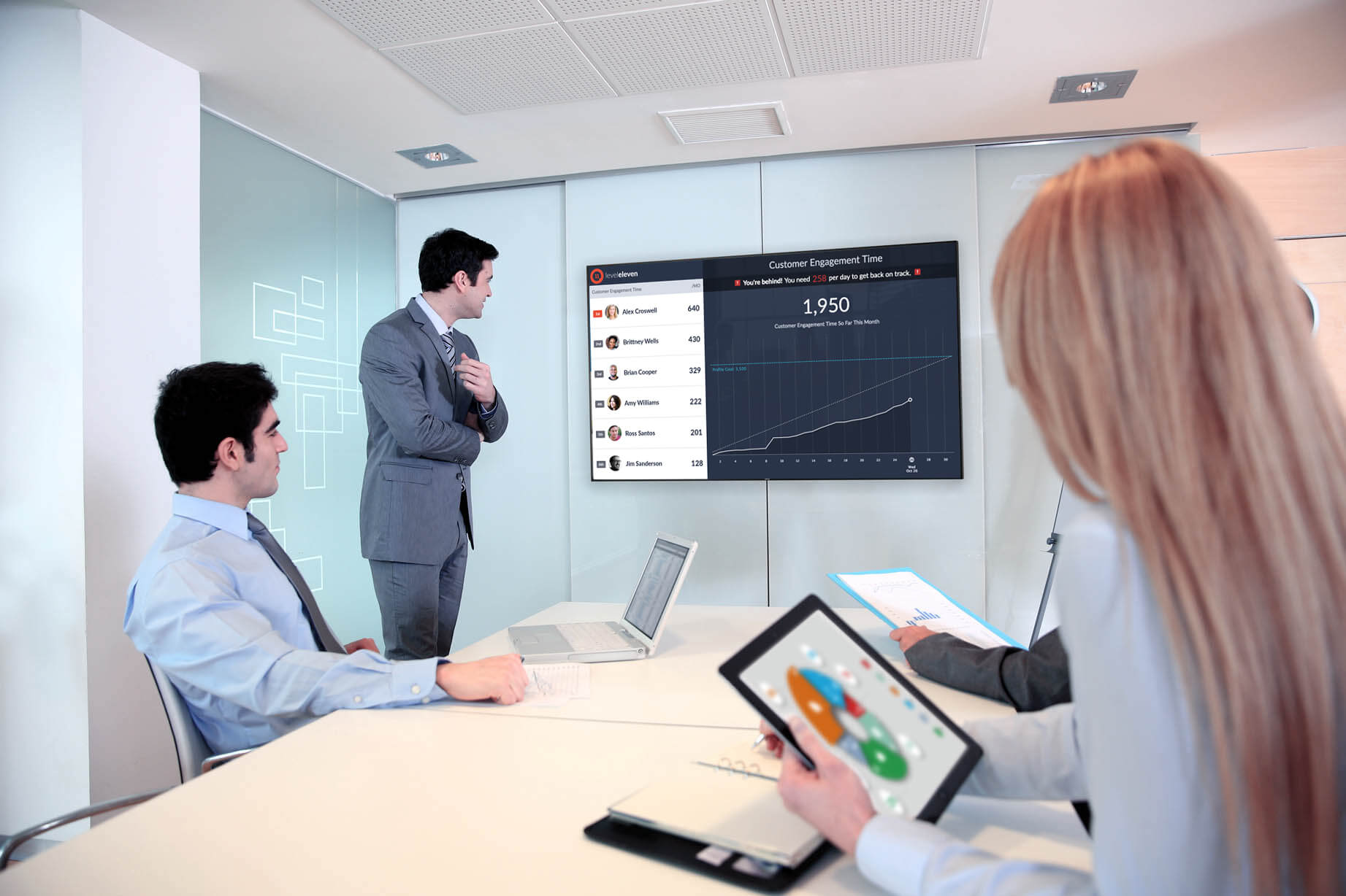 workspace with three people at a table looking at a displayed image