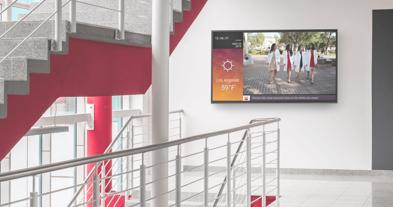 lobby with a stair set and a digital display on a far wall