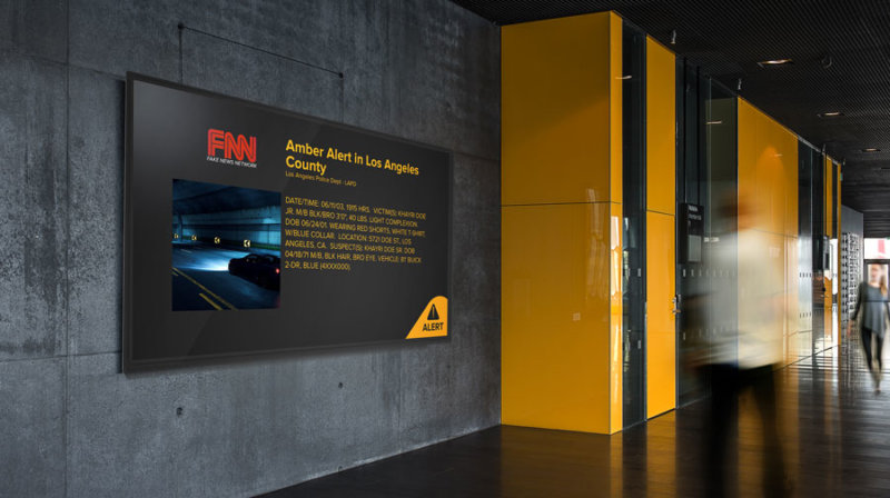 University hallway with digital sign showing an amber alert