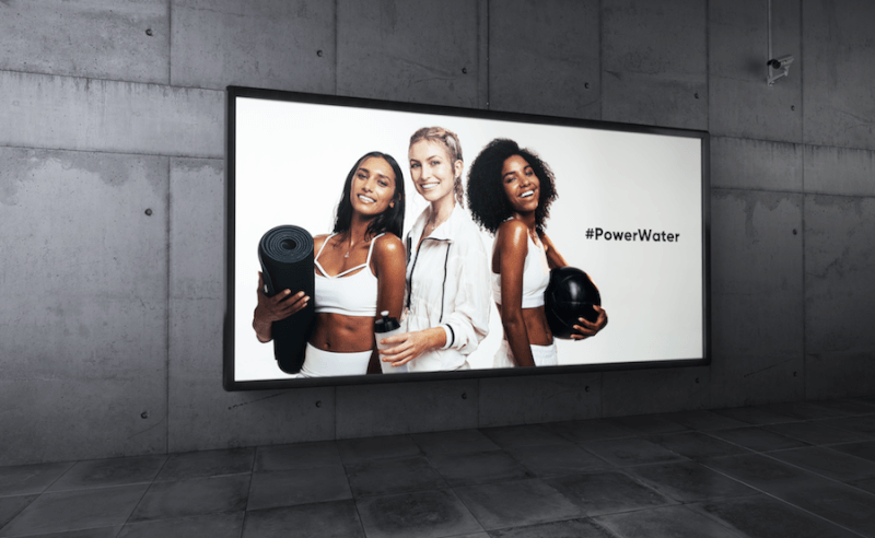 A digital screen showing a marketing video in an urban space