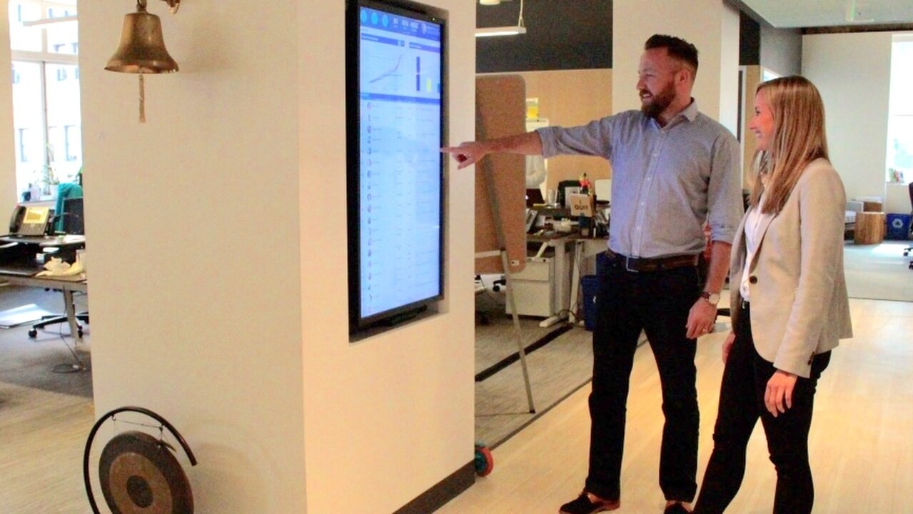 coworker showing another something on a vertical display screen