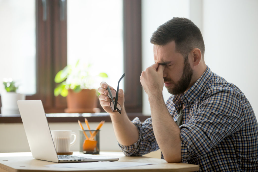 man looking stressed at his laptop