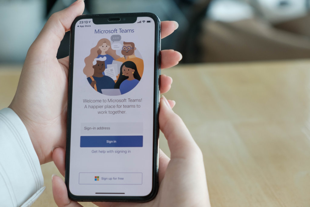 close up of someone holding phone with a microsoft teams app open