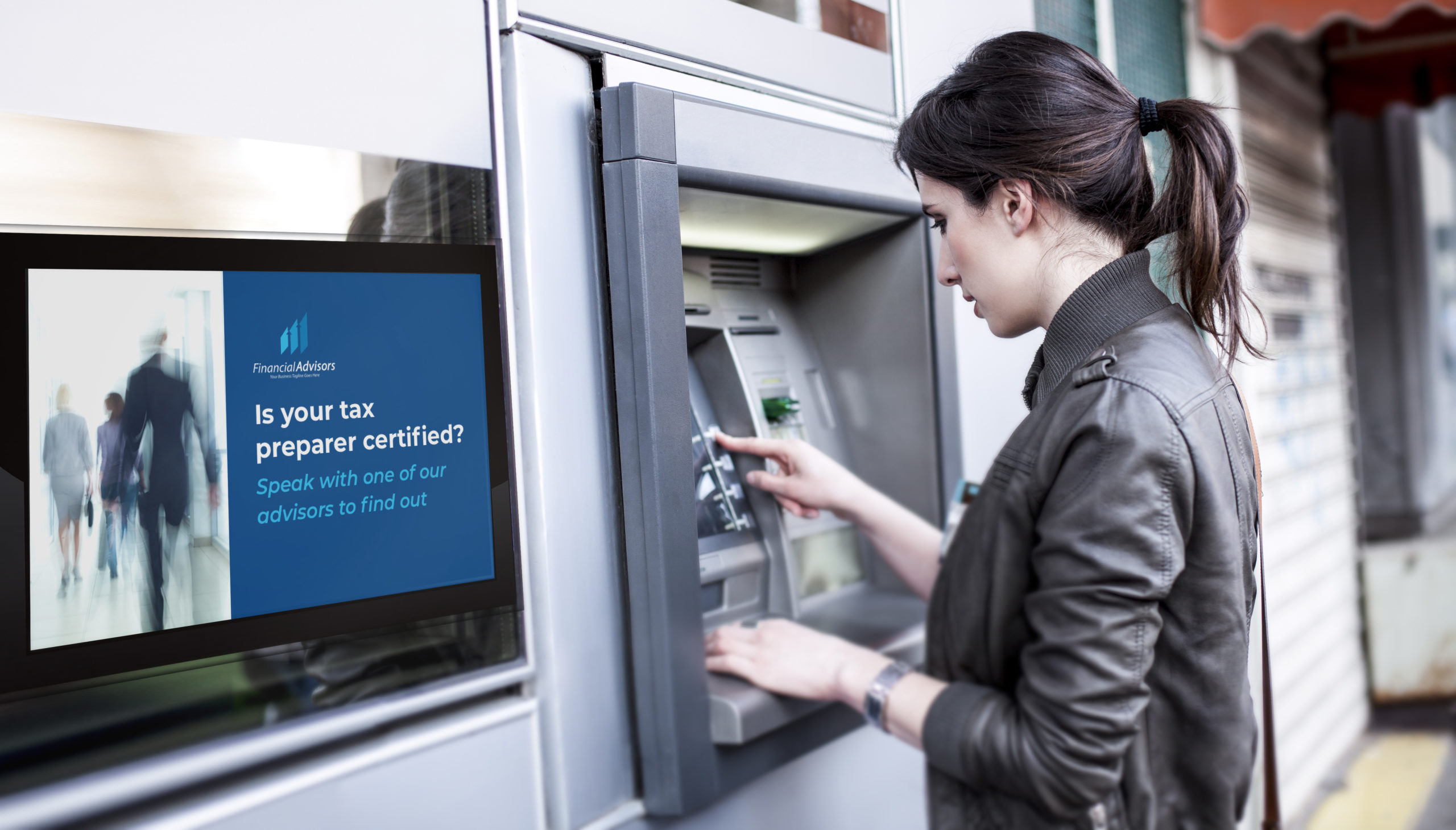 Young woman uses ATM with descriptive digital sign to her left