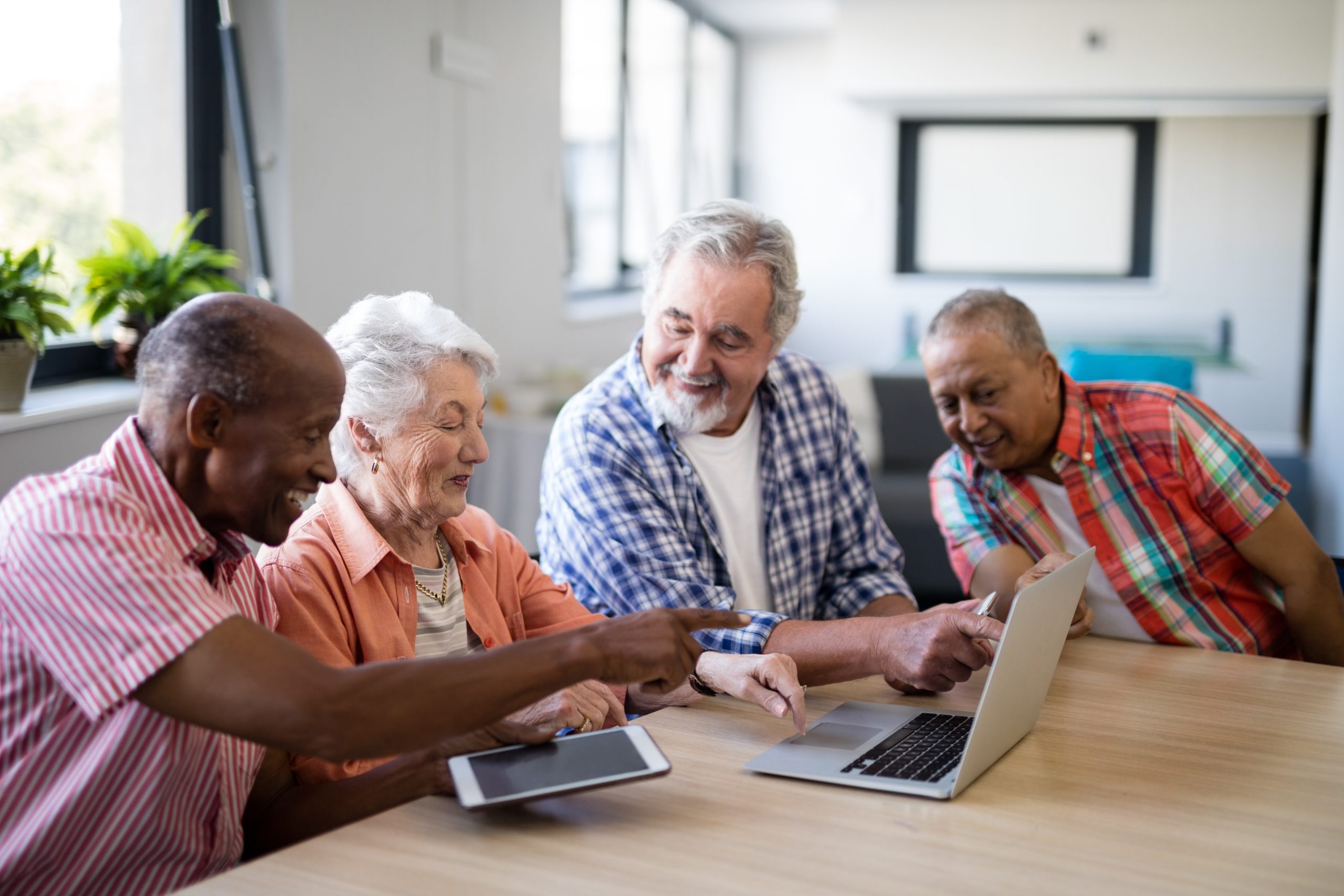 Group of elderly people at a table with computers