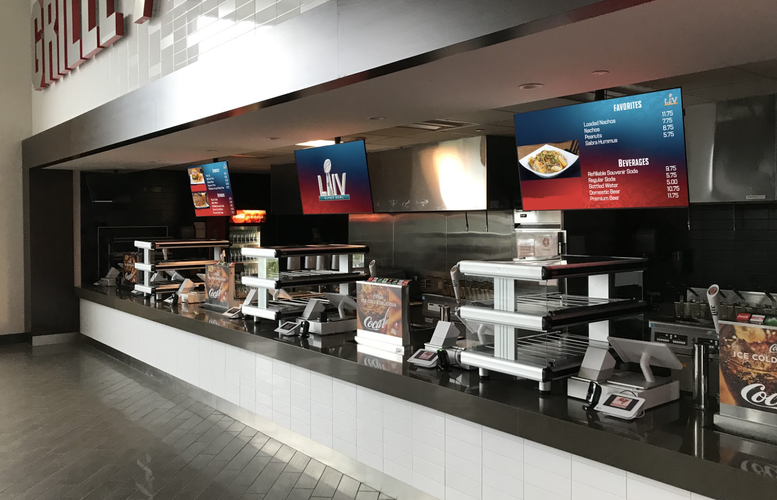 Concession stands at a stadium with Super Bowl LIV logos on digital menu boards