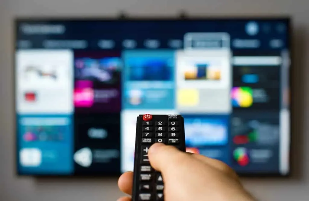 person pointing a remote at a smart tv