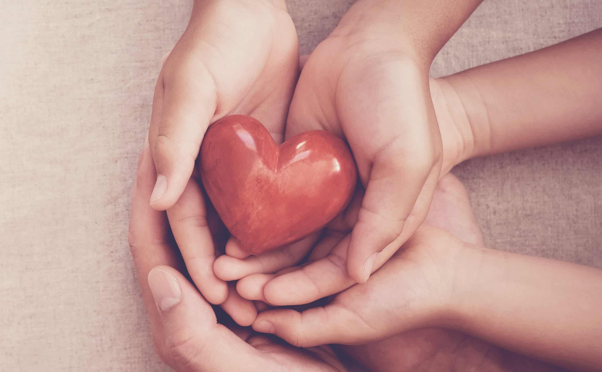 hands holding a decorative heart