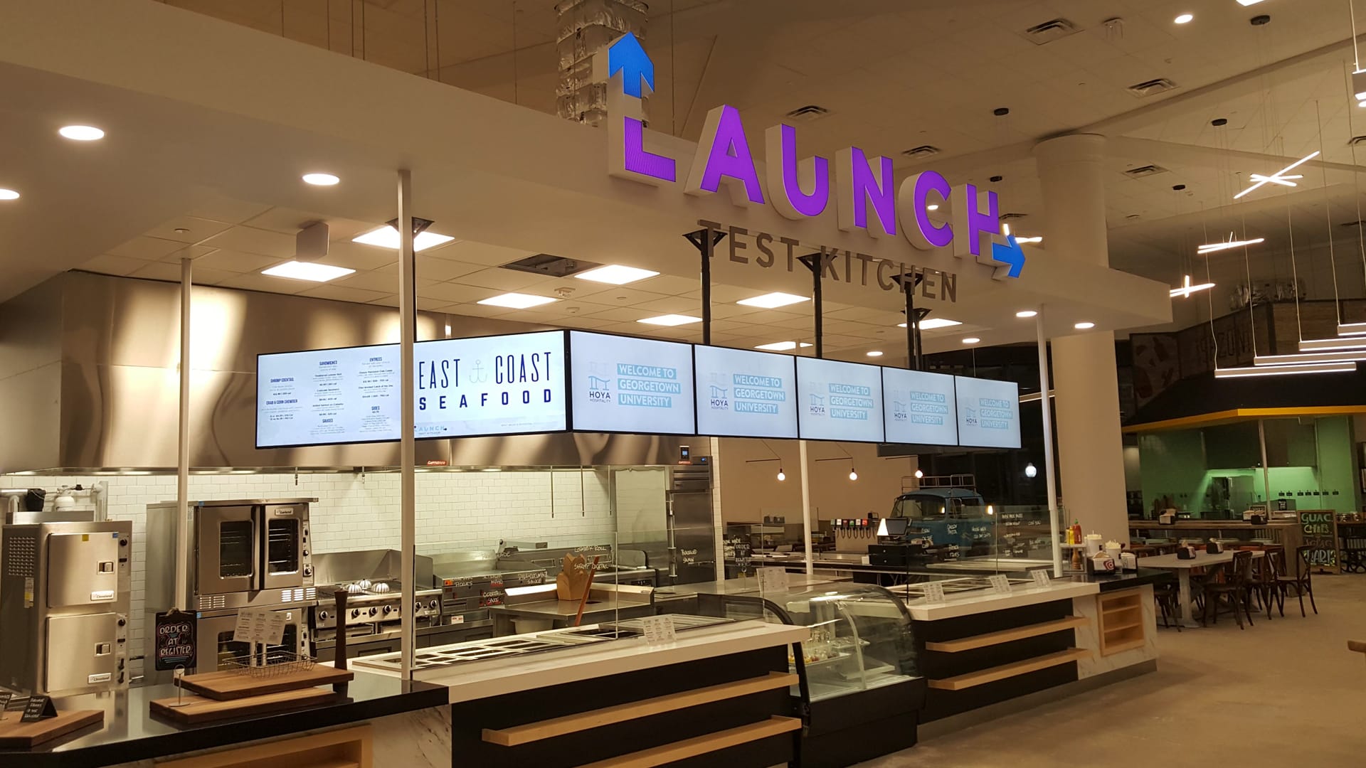 Multiple digital signs above a kitchen style diner