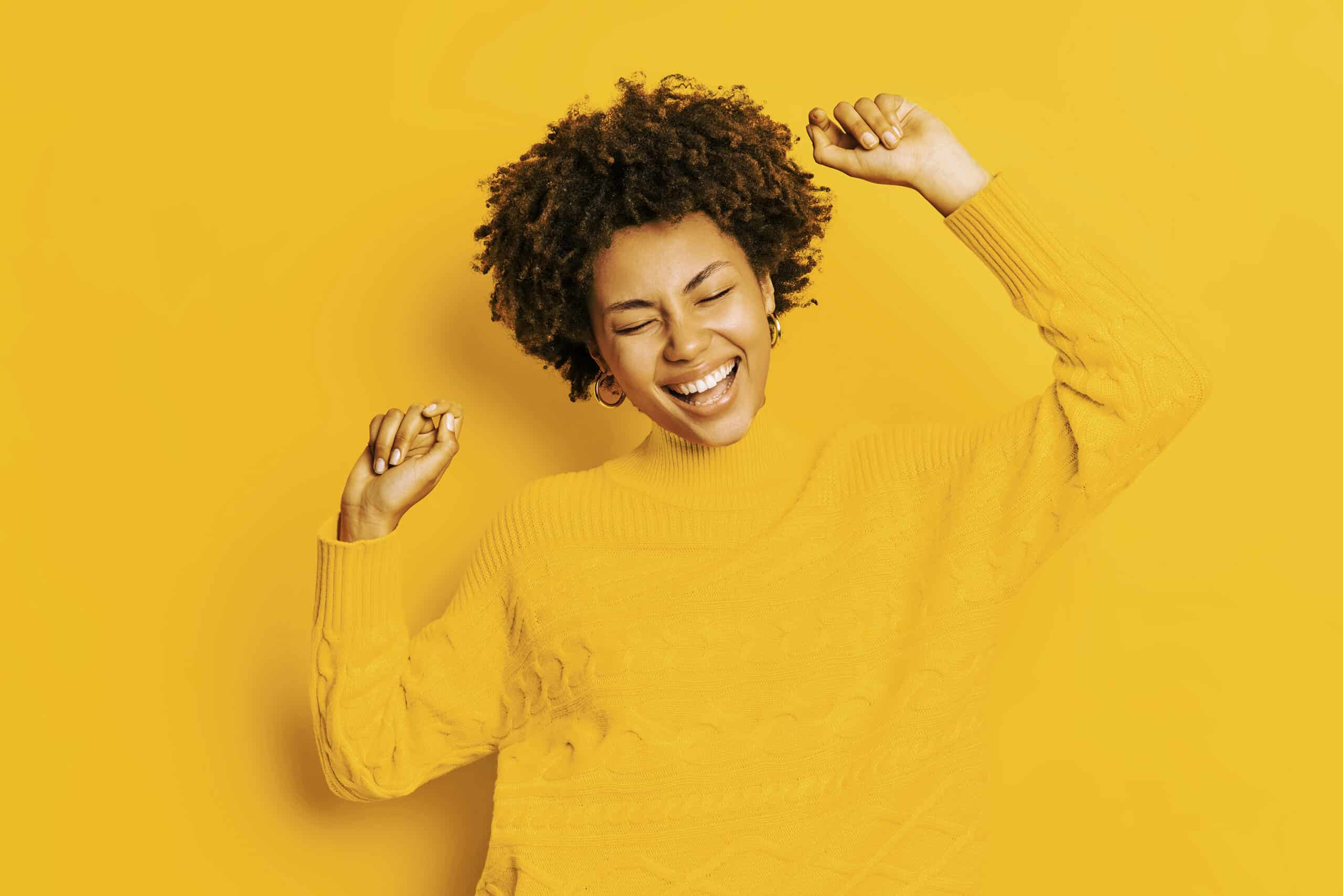 Lady happy dancing with a yellow background