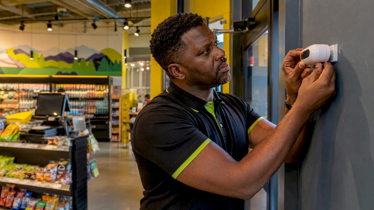 Store manager interacting with retail IoT sensor and signage